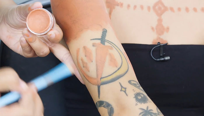 Makeup artist concealing a large tattoo on an arm with cover-up makeup. Makeup artist concealing a large tattoo on an arm with cover-up makeup.
