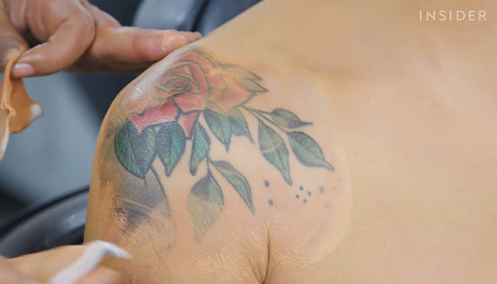 Makeup artist covering a large rose shoulder tattoo with concealer. Makeup artist covering a large rose shoulder tattoo with concealer.