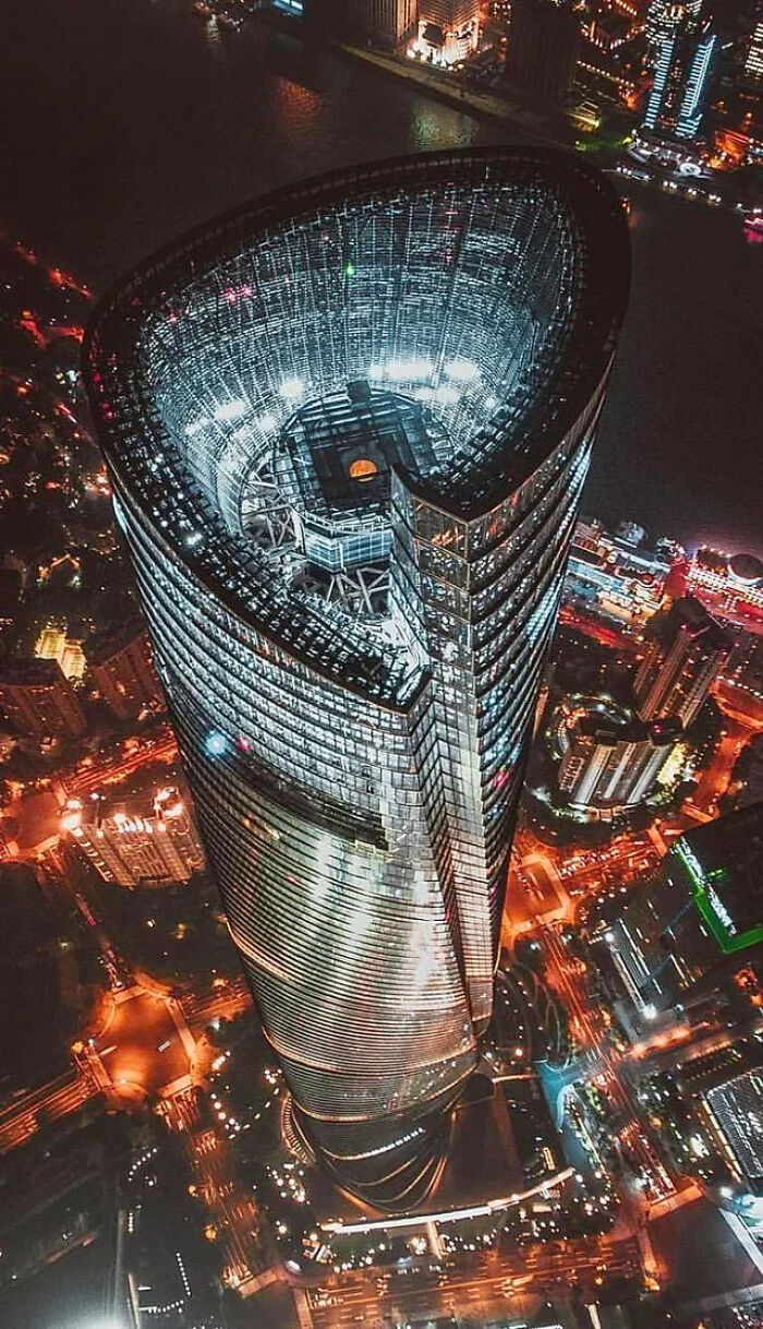 Aerial nighttime view of a towering skyscraper with bright lights, evoking fear in anyone with megalophobia.