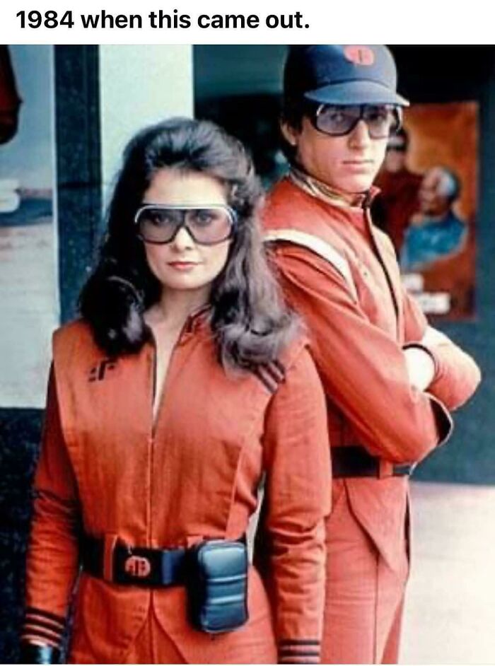 Two people in vintage 1980s orange uniforms and large glasses, evoking nostalgia and creaking joints reminders.