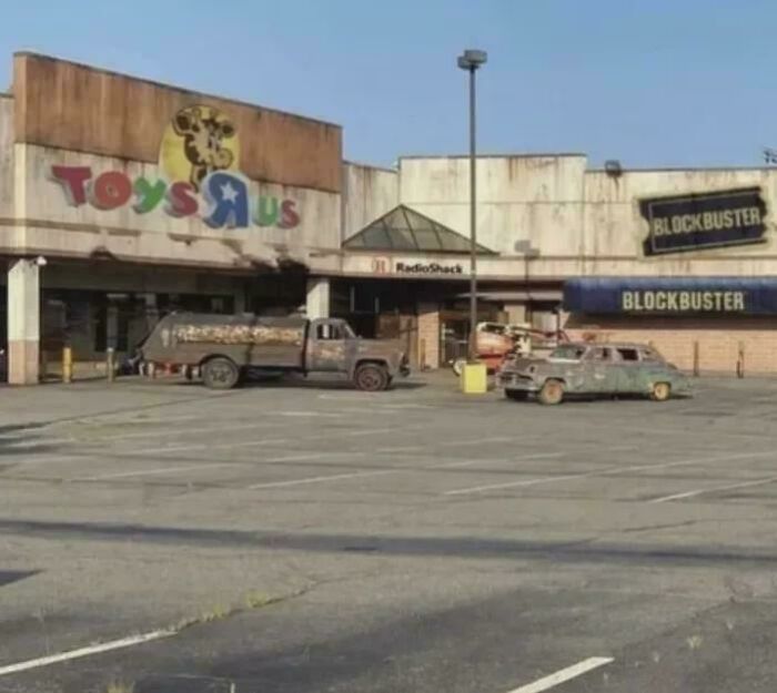 Abandoned Toys R Us and Blockbuster stores with rusted vehicles, evoking nostalgia and creaking joints memories.