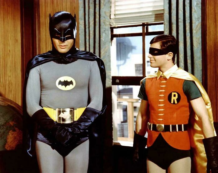 Classic Batman and Robin costumes worn by iconic superheroes, evoking nostalgia for creaking joints and old memories.