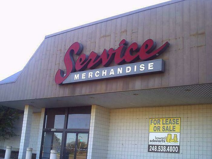 Old service merchandise store with vintage signage and a for lease or sale sign visible on the building exterior.