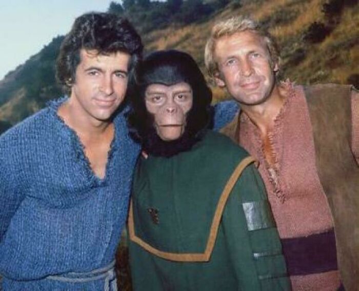 Two men posing with a person in a vintage ape costume, a nostalgic item that may remind you of aging and creaking joints.