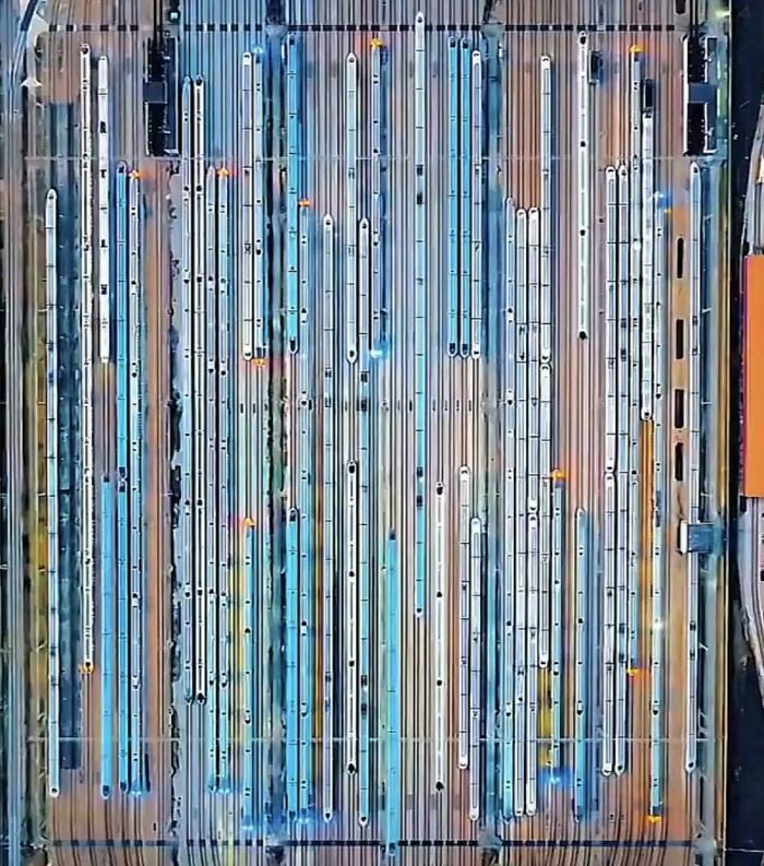 Aerial view of multiple trains lined up on parallel tracks creating a pattern that triggers megalophobia fear.