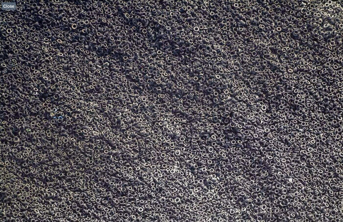 Aerial view of an enormous mountain of discarded tires creating a sprawling, chaotic scene for megalophobia.