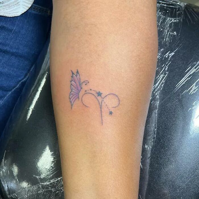 Bold Aries tattoo with stars and butterfly on an arm, aligned with cosmic design elements. Bold Aries tattoo with stars and butterfly on an arm, aligned with cosmic design elements.