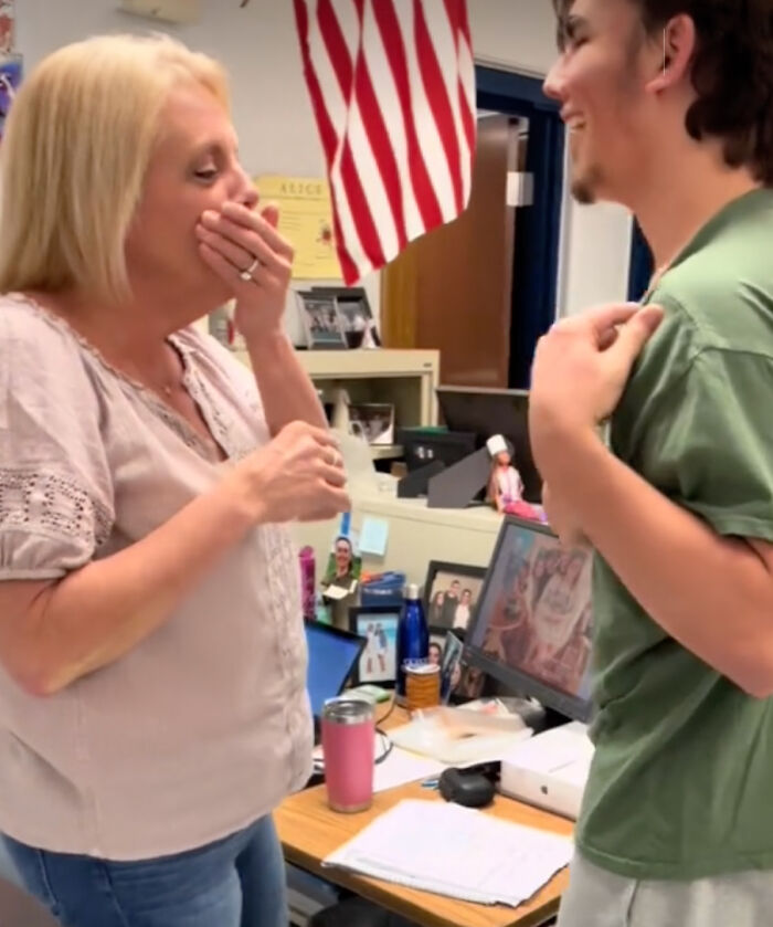 Teacher emotional as student reveals tattoo of her note on his chest, standing in a classroom setting. Teacher emotional as student reveals tattoo of her note on his chest, standing in a classroom setting.