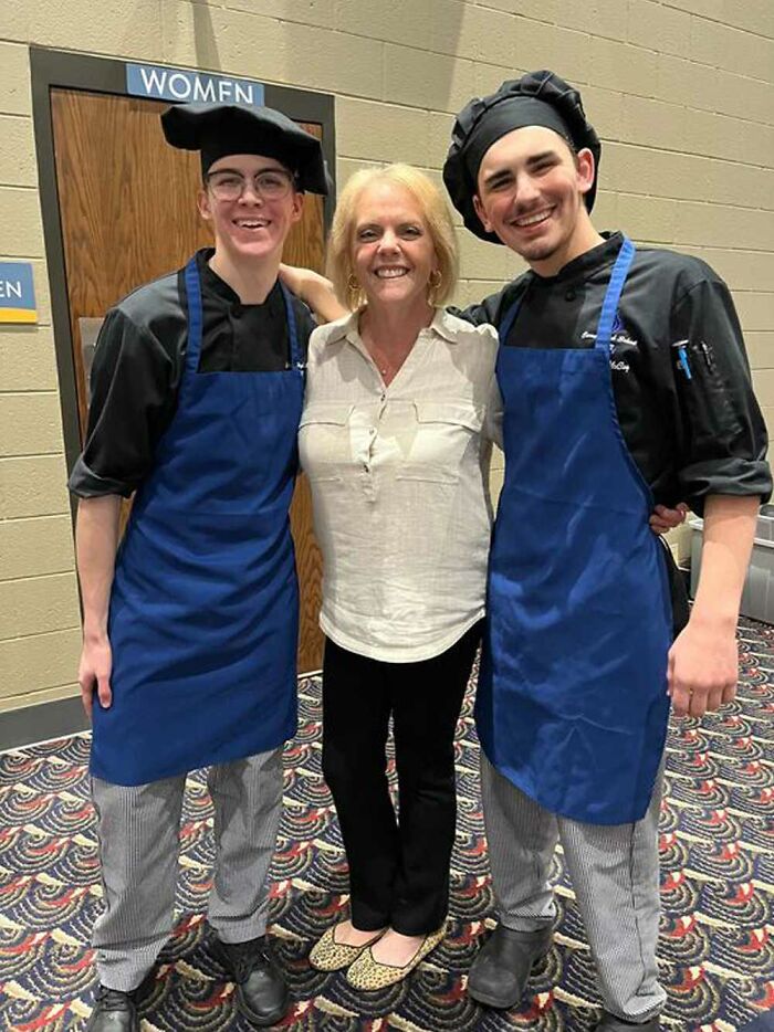 Teacher with two smiling students in chef attire, capturing a heartfelt moment. Teacher with two smiling students in chef attire, capturing a heartfelt moment.