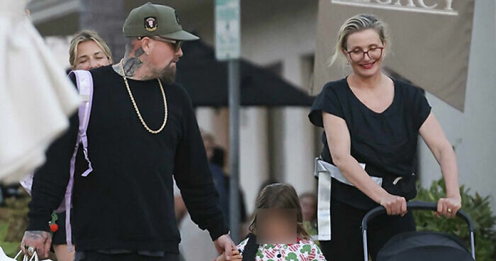 Cameron Diaz and Benji Madden walking outdoors with their two kids, enjoying a rare family outing together.