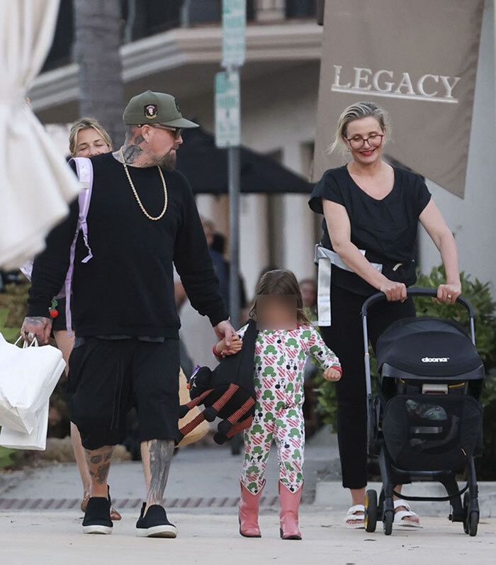Cameron Diaz and Benji Madden walking with their two kids during a rare family outing in casual attire outdoors. Cameron Diaz and Benji Madden walking with their two kids during a rare family outing in casual attire outdoors.