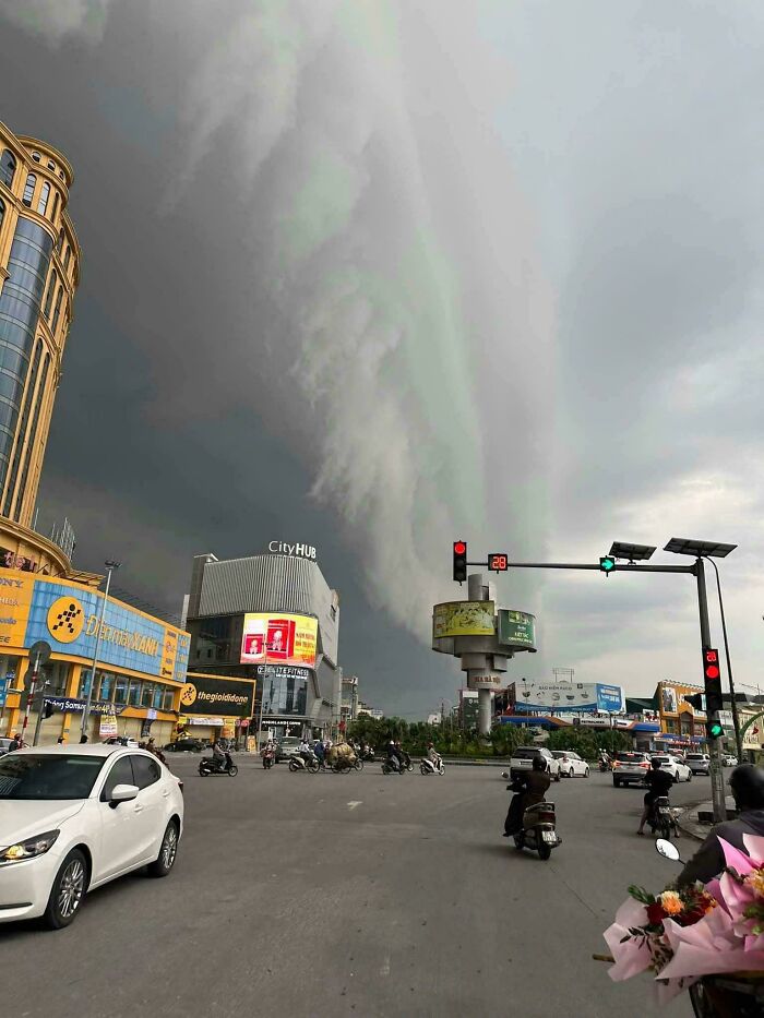 Dark ominous clouds over busy city intersection, an image that evokes fear for anyone with megalophobia.