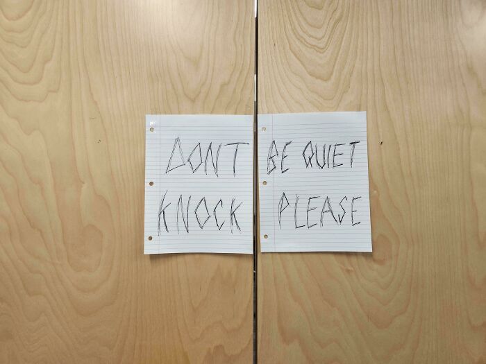 Handwritten sign fail on paper reads: "Don't knock, be quiet please," taped to wooden doors.