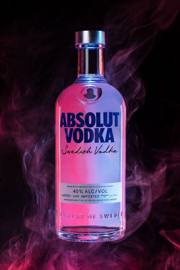 Absolut Vodka bottle in vibrant pink and purple lighting, showcasing top advertising photography from 2023 Budapest Foto Awards.