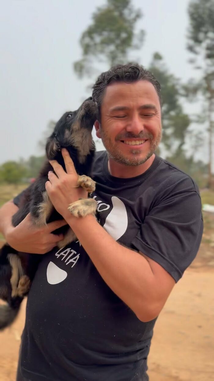Man smiling while holding a stray dog, symbolizing 25 years of compassion and care for animals. Man smiling while holding a stray dog, symbolizing 25 years of compassion and care for animals.