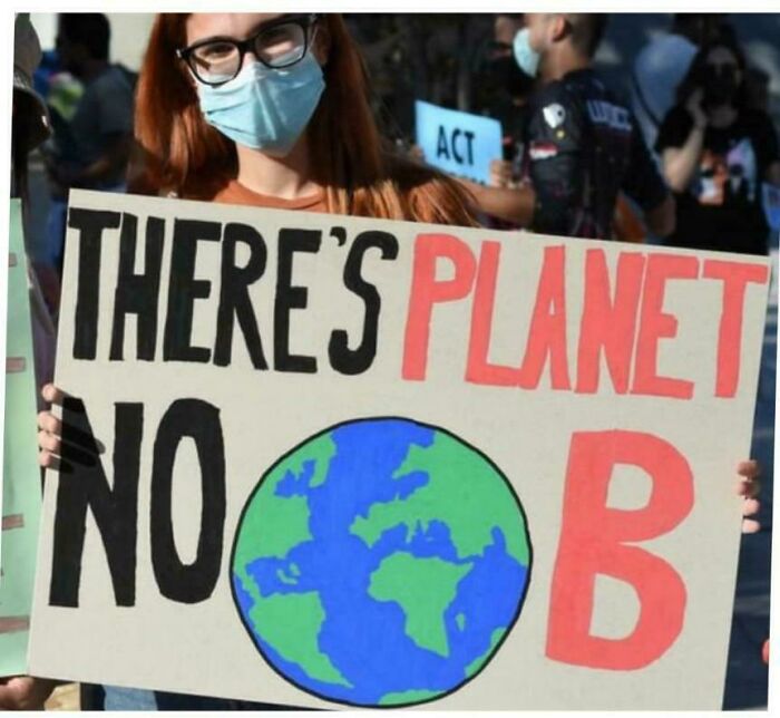 Person holding a sign reading "There's No Planet B" with Earth illustration, highlighting sign message fails.