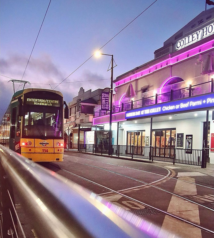 Tram passing by a vibrant bar with purple lights in Hindmarsh. Tram passing by a vibrant bar with purple lights in Hindmarsh.
