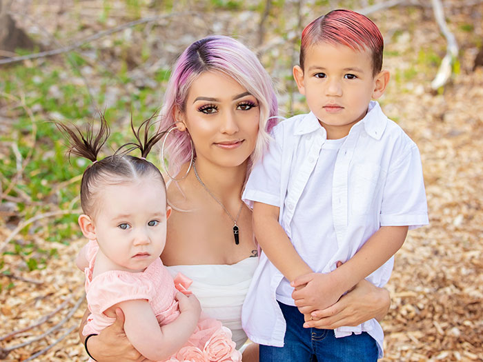 A single mom with her two children outdoors, capturing a heartfelt moment. A single mom with her two children outdoors, capturing a heartfelt moment.