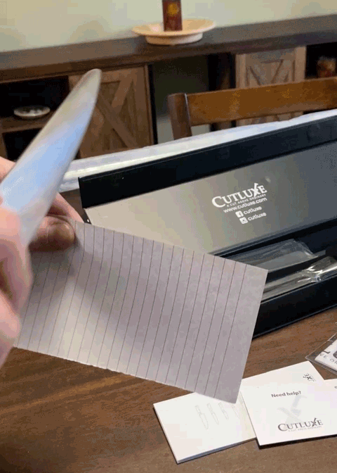 Sharp kitchen knife cutting a lined recipe card, illustrating small luxuries for hosting Thanksgiving with ease and style.