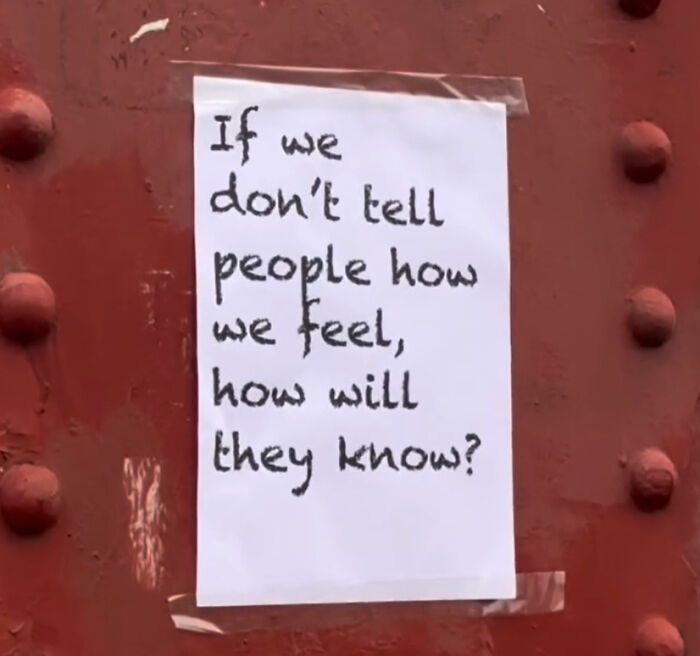 Handwritten wholesome message taped to a red wall in London, expressing feelings to touch people's hearts.