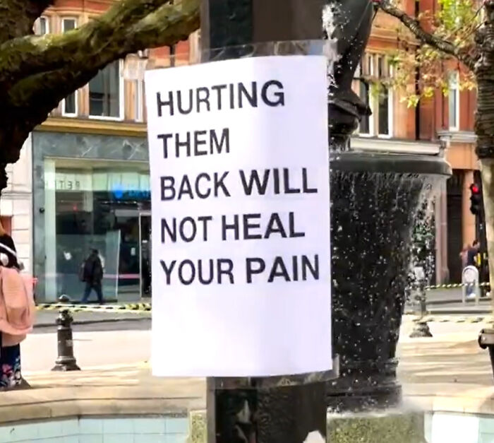 Wholesome message on London street sign saying hurting others back will not heal your pain in public space.