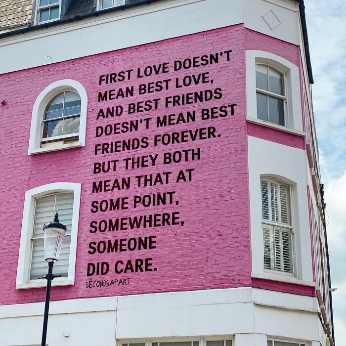 Pink wall mural in London featuring a wholesome message about love and friendship seen in the streets of London.