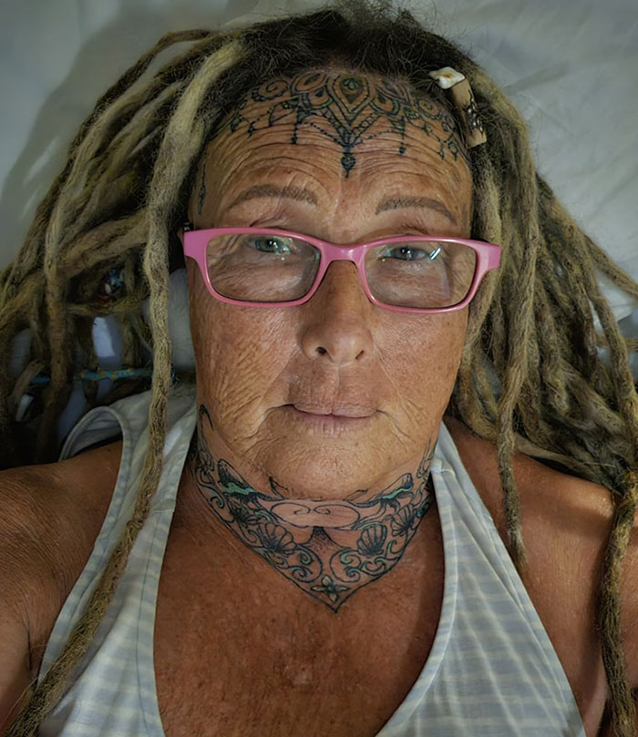 Woman with face tattoos and dreadlocks wearing pink glasses, looking directly at the camera. Woman with face tattoos and dreadlocks wearing pink glasses, looking directly at the camera.