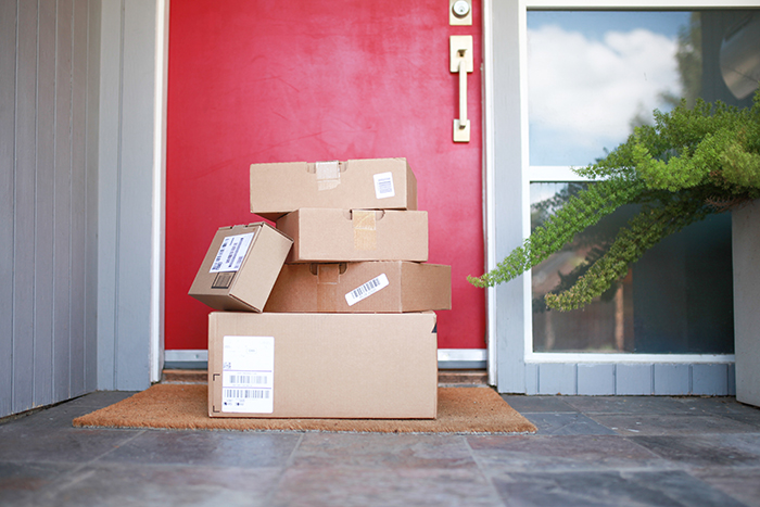 Several packages stacked on a doorstep, illustrating shopaholic tenants' deliveries. Several packages stacked on a doorstep, illustrating shopaholic tenants' deliveries.