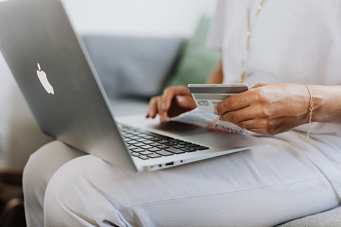 Person shopping online with a laptop and credit card, related to a shopaholic theme. Person shopping online with a laptop and credit card, related to a shopaholic theme.