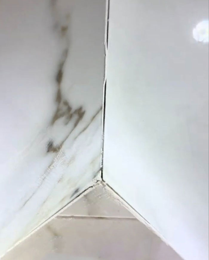 Flawed tile corner in a $1,600,000 home, revealing construction issues in a two-year-old house. Flawed tile corner in a $1,600,000 home, revealing construction issues in a two-year-old house.