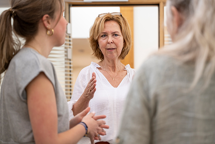 Woman looking surprised while talking with two others about family plans. Woman looking surprised while talking with two others about family plans.