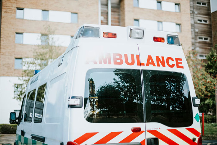 Ambulance parked in front of a building under a clear sky, related to an employee being taken to the hospital. Ambulance parked in front of a building under a clear sky, related to an employee being taken to the hospital.