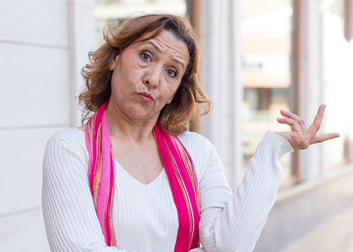 Neighbor woman in white sweater and pink scarf making a dismissive gesture outside. Neighbor woman in white sweater and pink scarf making a dismissive gesture outside.