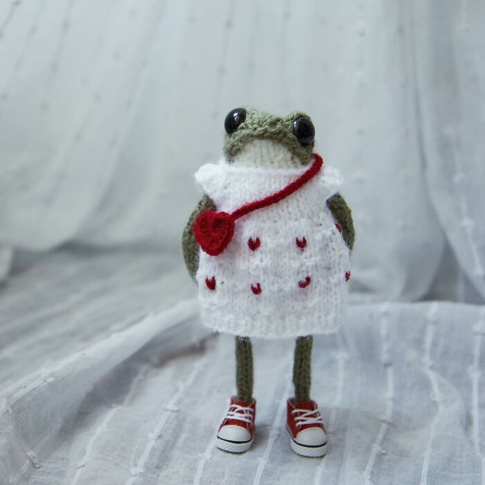 Knitted miniature frog wearing a cute dress and red sneakers, crafted by a talented French knitter.