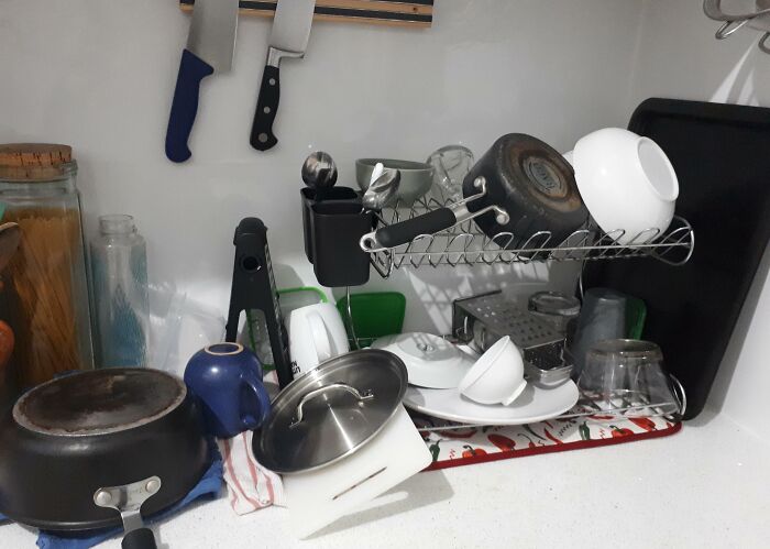 Messy kitchen counter with dishes and pots scattered, showcasing infuriating boyfriends' husbands' habits.