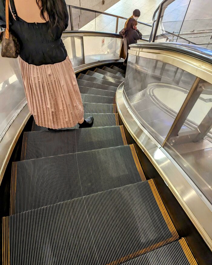 Stylish curved escalator design in use, highlighting impressive attention to detail and creativity.