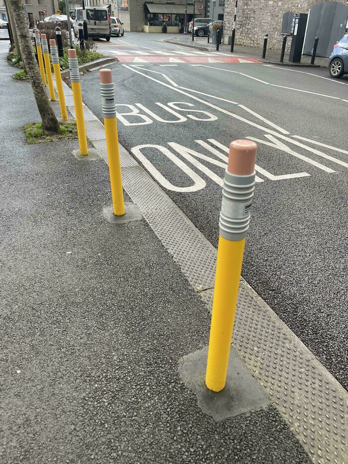 Creative design: bollards painted as pencils in a "Bus Only" lane, showcasing clever urban design.