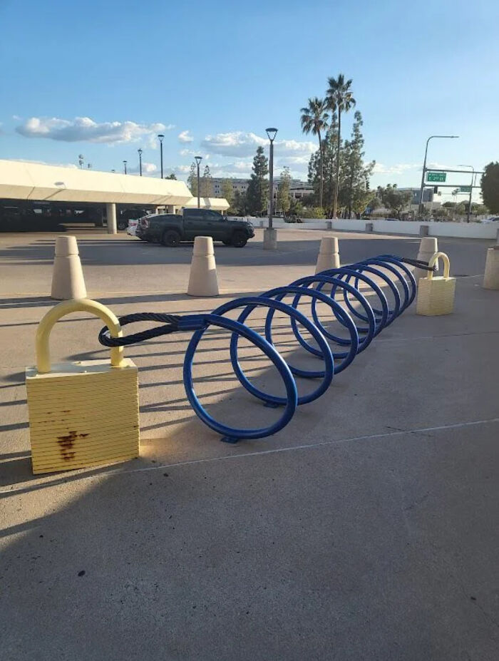 Creative bike rack designed to look like a gigantic padlock and coil, showcasing ingenious designer creativity.