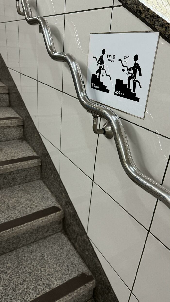 Creative handrail design on stairs with instructional sign.