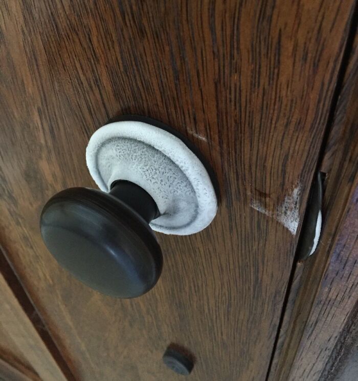 Wooden door with ice-cold frost around the doorknob, creating a winter scene effect.