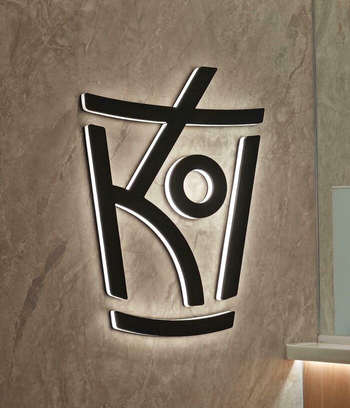 Creative wall logo design glowing on a textured surface.