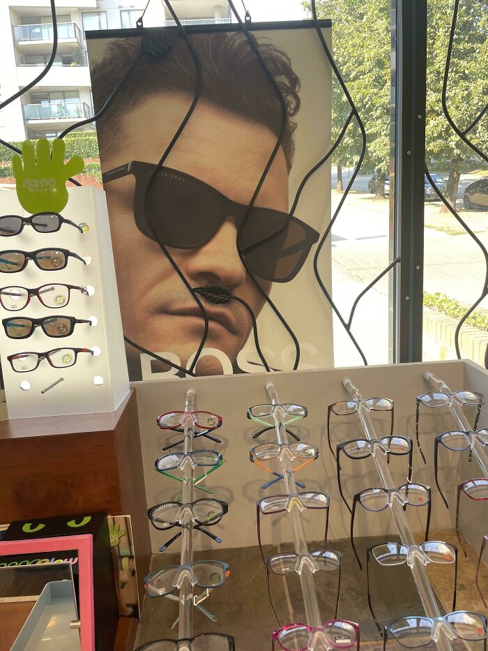 Funny ad fail with glasses display blocking man's mustache in poster.