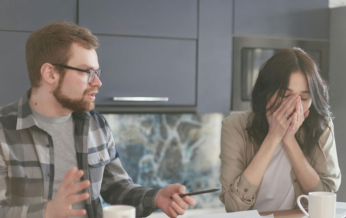 Father and woman in tense conversation at a kitchen table, highlighting family drama. Father and woman in tense conversation at a kitchen table, highlighting family drama.