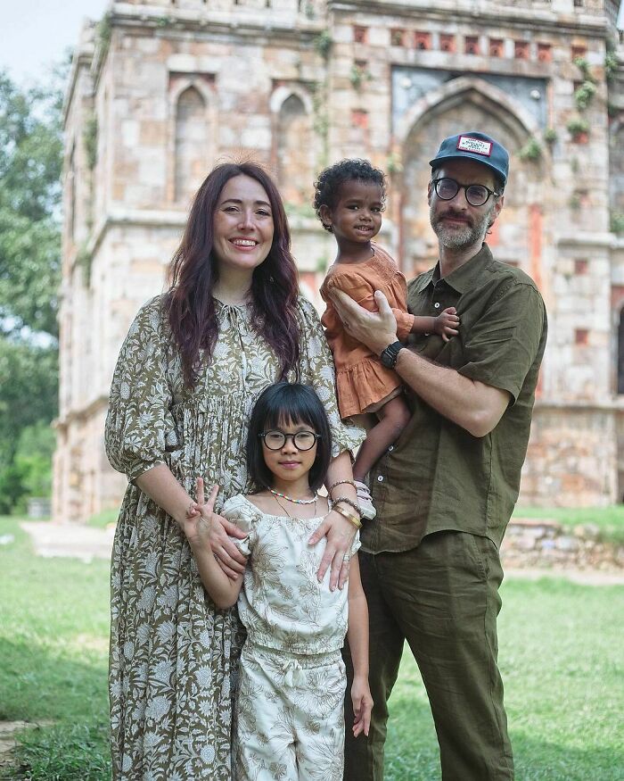 Family enjoying a day out in front of an old building, representing wholesome adoption stories.
