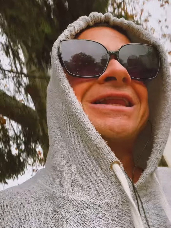 Rock singer in sunglasses and hoodie outdoors, discussing detransition plans. Rock singer in sunglasses and hoodie outdoors, discussing detransition plans.