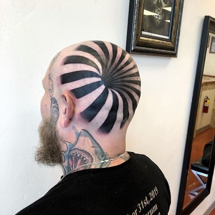 Bald man with spiral tattoo on head, showcasing an epic tattoo fail. Bald man with spiral tattoo on head, showcasing an epic tattoo fail.