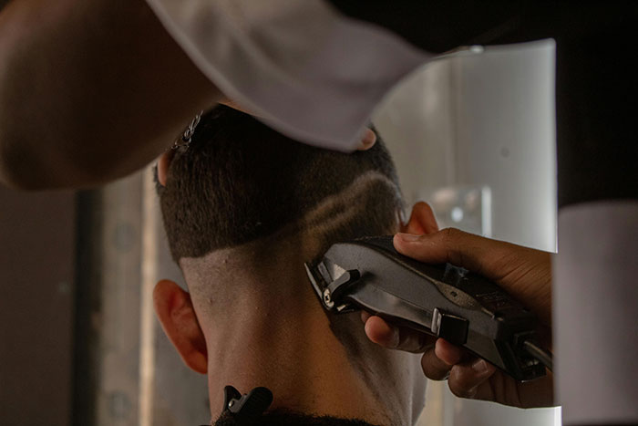 Person getting a haircut with clippers, showcasing precise hairstyle technique. Person getting a haircut with clippers, showcasing precise hairstyle technique.