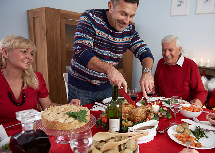 Family gathering at dinner table with festive holiday meal preparation. Family gathering at dinner table with festive holiday meal preparation.
