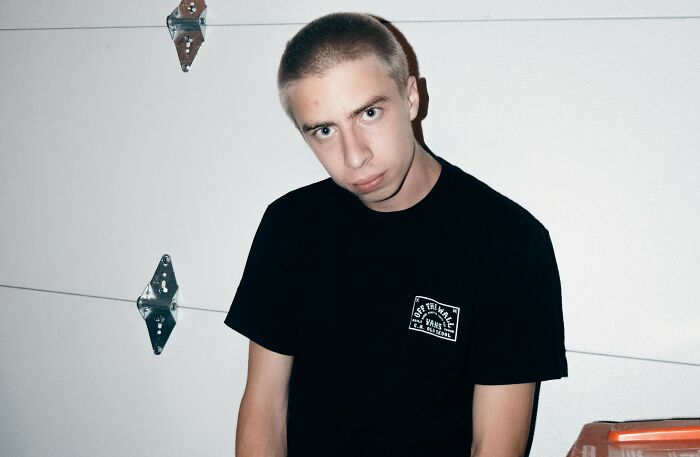 Teenager with a shaved head in a black T-shirt, illustrating autistic son's aggression concerns. Teenager with a shaved head in a black T-shirt, illustrating autistic son's aggression concerns.