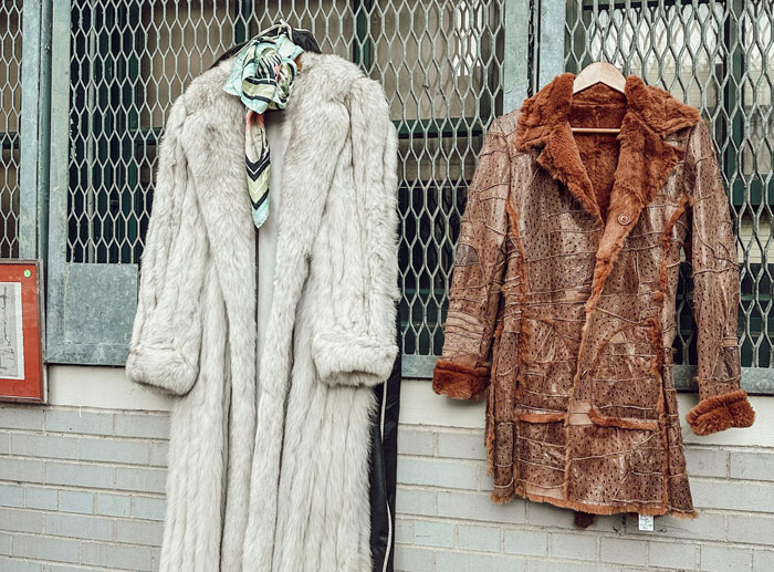 Vintage fur coats hanging outside on a rack, symbolizing family heirlooms and moral dilemmas. Vintage fur coats hanging outside on a rack, symbolizing family heirlooms and moral dilemmas.